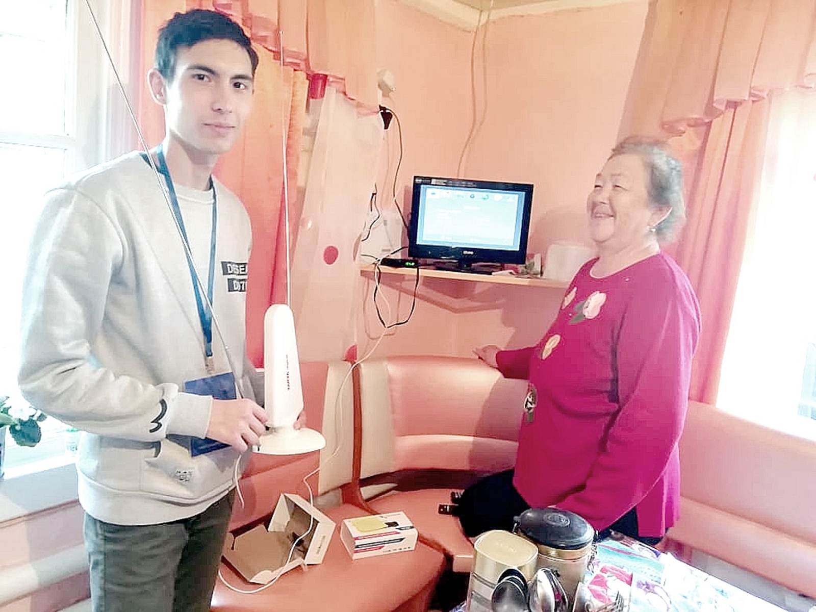 Волонтер Денис Никишин помогает  Кларе Ямилевне Сиргалиной разобраться с подключением цифрового телесигнала.